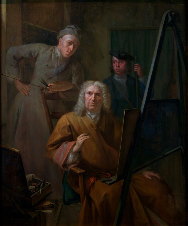 De drie figuren zijn in een ruimte. Één van de mannen zit op een stoel voor een schildersezel. De man daarachter heeft een pallet met kwasten vast.