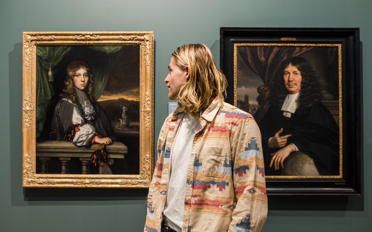 Jongen tussen twee schilderijen in