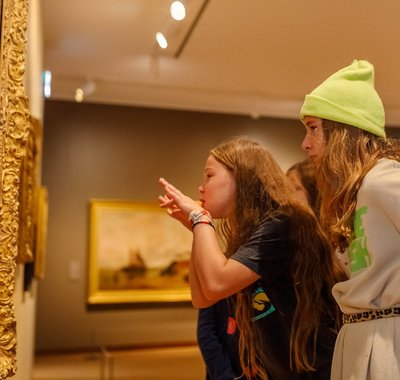 Twee jonge meisjes met daarachter nog meer leerlingen, kijken naar een schilderij in Dordrechts Museum tijdens Schoolprogramma Kijken is een kunst.