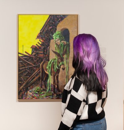 Vrouw kijkt naar schilderij van Umar Rashid in het Dordrechts Museum.