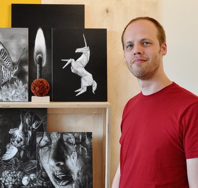 Niek Hendrix in zijn atelier. Links van hem staan diverse kunstwerken