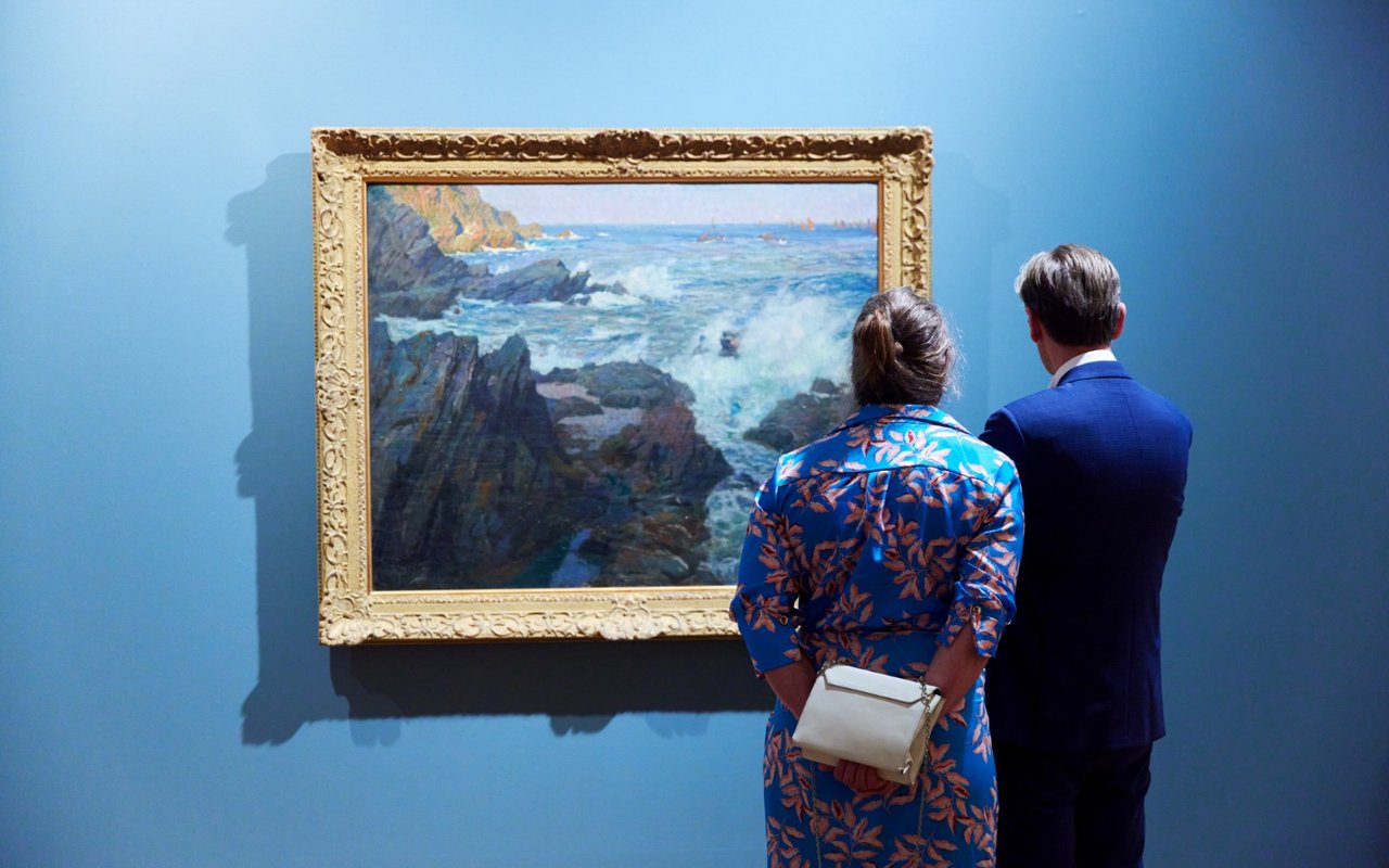 De opening van de tentoonstelling Wanderlust in het Dordrechts Museum. Bezoekers bekijken een schilderij aandachtig.