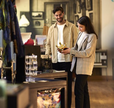 Twee mensen staan in de museumwinkel en bekijken een item.